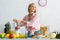 Girl adding ingredients in blender while smiling in kitchen