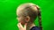 The girl adjusts lightly blond hair on her head. Profile