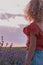 Girl admiring sunset over purple field lavender flowers. Inspiring scene childhood dreams. Family summer holiday, relax