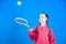 Girl adorable child play tennis. Practicing tennis skills and having fun. Athlete kid tennis racket on blue background