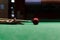 Girl aims to hit the ball while playing billiards