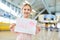 Girl at the airport holds up a sign