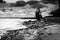 The girl along the beach went away. Abandoned heart in sand. Black and White Photography. Dramatic lights.