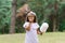 Girl in an amusement park in the summer eats cotton candy and smiles happily. The concept of summer holidays and school holidays