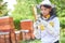 Girl analyzing hive fork and brush at apiary garden