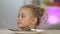 Girl appearing from under table and stealing piece of chocolate bar, sweet-tooth