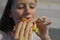 Girl with appetite eats delicious hamburger. child bites off large piece of sandwich