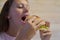 Girl with appetite eats delicious hamburger. child bites off large piece of sandwich