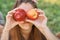 Girl with Apple in the Apple Orchard. Beautiful Girl Eating Organic Apple in the Orchard. Harvest Concept. Garden, teenager eating