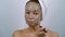 Girl applying mud mask on face after bath