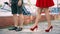 The girl approaches the guy in red shoes and in a red dress,close-up