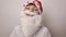 Girl with artificial beard in Santa Claus hat smiles, laughs on white background