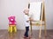 Girl, the artist draws on easel bear