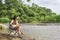 The girl asia enjoys a beautiful sunset sitting on a bench by the river. Girl sitting near water outdoor