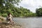 The girl asia enjoys a beautiful sunset sitting on a bench by the river. Girl sitting near water outdoor