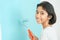 Girl Asian painting wall with the paint roller Close-up, Hand of young child renovation or decorating the interior home with the
