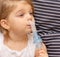girl with asthma and allergies makes inhalations through the nose with medication through a nebulizer