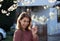 Girl with asthma pump in front of blooming tree in spring