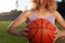 Girl athlete biketball player, holding a biketball ball in her hand, against the backdrop of the setting sun. Outdoors