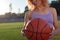 Girl athlete biketball player, holding a biketball ball in her hand, against the backdrop of the setting sun. Outdoors