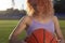 Girl athlete biketball player, holding a biketball ball in her hand, against the backdrop of the setting sun. Outdoors