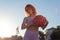 Girl athlete biketball player, holding a biketball ball in her hand, against the backdrop of the setting sun. Outdoors