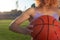 Girl athlete biketball player, holding a biketball ball in her hand, against the backdrop of the setting sun. Outdoors