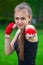 The girl the athlete, the boxer, in the park also gives the hand compressed in a fist forward with the reeled sports, red bandage.