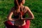 Girl athlete does a namaste pose from behind. Young female body hands closeup on a background of sunset