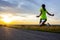 Girl athlete jumps up against the sunset sky