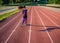 Girl athlete runs on the stadium at sunset