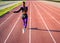 Girl athlete runs on the stadium at sunset