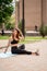 Girl athlete in sports apparel stretching in Park