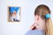 Girl attentively looks photos on wall