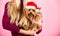 Girl attractive blonde hold dog pet pink background. Woman and yorkshire terrier wear santa hat. Celebrate christmas