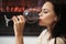 Girl attractive woman makeup face drinking wine wineglass background fireplace background. Luxury wine. Enjoy noble