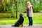 Girl in autumn park training her dog in obedience