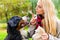 Girl in autumn park training her dog in obedience