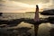 The girl on the background of a beautiful seascape and sunset, silhouette of a girl on a cliff, on a cliff,
