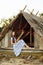 Girl on the background of an old thrown wooden house. girl in white dress with blue embroidery flowers