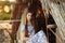 Girl on the background of an old thrown wooden house. girl in white dress with blue embroidery flowers