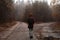 Girl with backpack from behind at the crossroad in the woods who don\'t know which way to go