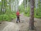 A girl with a backpack goes hiking along a forest path and looks back