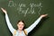 Girl with backpack pointing at chalkboard with do you speak English lettering