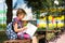 Girl with a backpack sitting on a bench and reading a book near the school. Back to school, lesson schedule, a diary with grades.