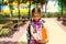 Girl with a backpack and a stack of books near the school. Back to school, the child is tired, heavy textbooks. Education, primary