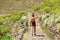 Girl with backpack walks along the mountain path. A woman is walking along a stony road in Tenerife