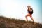 Girl backpacker, alone, climbing a hill on summer evening