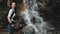 Girl backpacker enjoy waterfall in rainforest