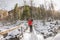 Girl backpacker walking on a bridge over a frozen river in the w